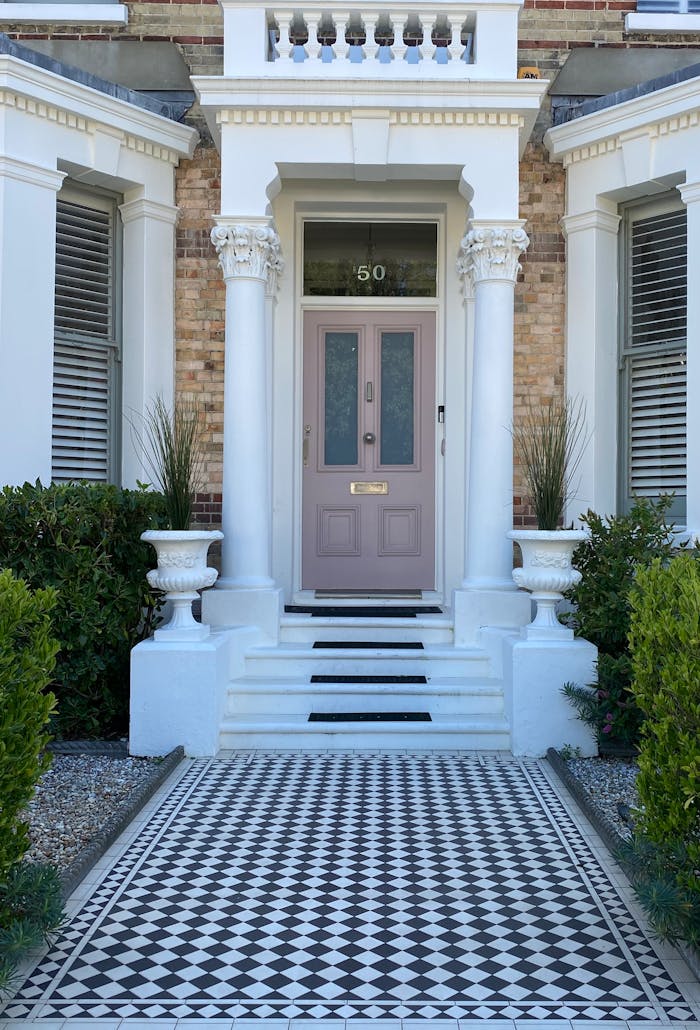 Services Beautiful Victorian house entrance featuring columns and black and white tile pathway.