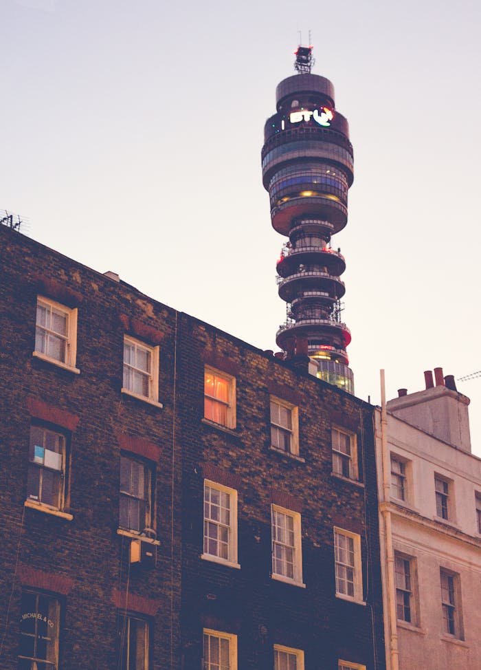 Home Low-angle view of the BT Tower against a cityscape at dusk in London, UK.